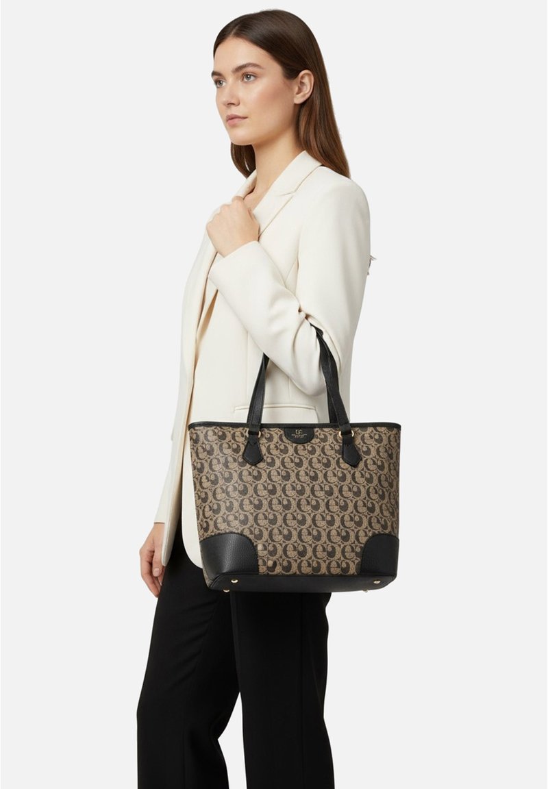 Borsa tote con motivo monogram marrone, dettagli in pelle nera, doppi manici e forma strutturata. Presenta ferrature dorate e base a contrasto.