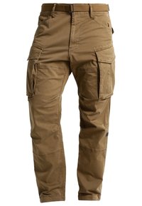Pantaloni cargo in tessuto di cotone color sabbia con molteplici tasche, cinture e una vestibilità ampia. Presentano dettagli cuciti e cuciture rinforzate.