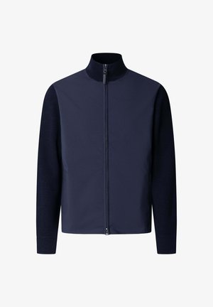 Jakna tamnoplave boje na patent s visokim ovratnikom, dugim rukavima i glatkim prednjim dijelom koji kontrastira s pletenim rukavima i stražnjim dijelom.