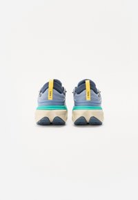Scarpe da corsa blu con suola ammortizzata, dotate di un linguetta gialla, accenti grigi e una intersuola turchese. Parte superiore in tessuto testurizzato.