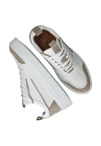 Witte leren en beige suède sneakers met een gestructureerde rubberen zool, vetersluiting en geperforeerde accenten aan de zijkanten.