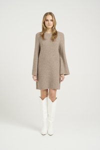 Rochie tricotată bej, cu mâneci evazate, hem până la genunchi și textură cu nervuri, asortată cu cizme albe cu lungimea genunchiului și vârfuri ascuțite.