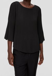 Svart plisserad topp med rund halsringning och trekvartsflared ärmar, med en mjuk textur och flödande silhuett.