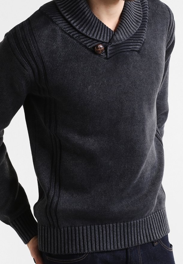 Homme portant un pull en maille gris foncé avec un col, des poignets et un ourlet côtelés, avec un seul gros bouton près de l'encolure.