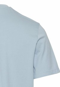 Lyseblå bomulds T-shirt med rund hals og korte ærmer. Glat tekstur med lige kant og minimale syninger.