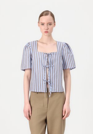 Blouse courte rayée bleue et blanche avec un décolleté carré, des manches bouffantes et un détail de lien central. Tissu texturé avec des accents marron.