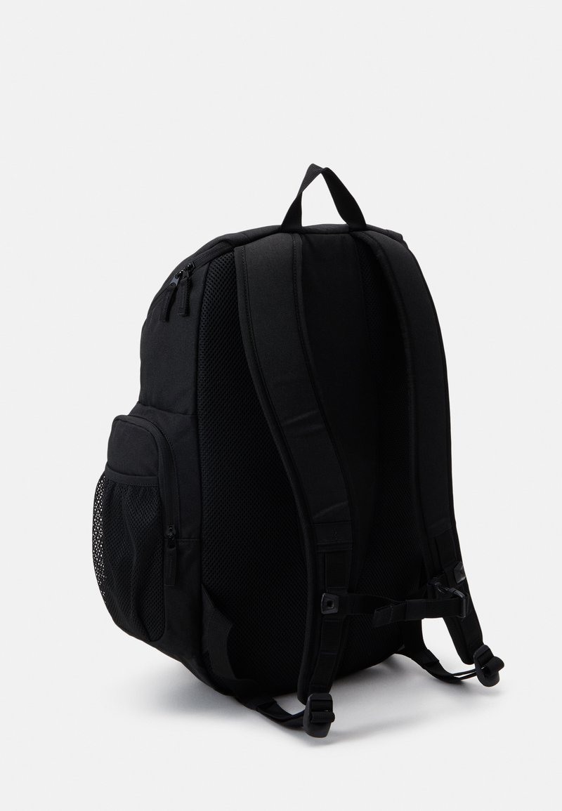 Zaino nero con spallacci imbottiti, tasca laterale in rete e molteplici scomparti con zip. Texture del tessuto morbida, forma strutturata.