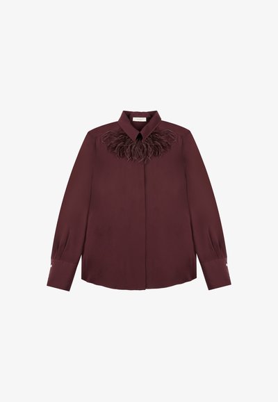 Long-sleeve burgundy blouse with collar and feather trim detail across the chest, buttoned cuffs, and a concealed front placket.