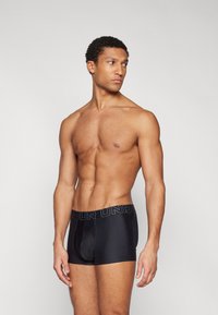 Zwarte boxershorts met een elastische tailleband met logo, gemaakt van een zachte, rekbare stof, met een aansluitend ontwerp en zonder zichtbare naden.