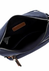 Borsa in tessuto navy con apertura con zip, accentuata in pelle marrone e un interno spazioso. Accessori metallici argentati e texture liscia.