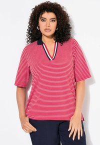 Polo rayé rouge et blanc avec un col marine, à manches courtes et design en V. Tissu léger. Coupe moderne.