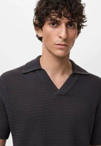 Maglione a maniche corte lavorato a maglia di colore grigio scuro con un motivo testurizzato, colletto a V e bordi a coste in contrasto. Tessuto liscio e leggero.