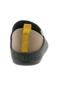 Zapatilla de felpa gris con parte superior de tela color beige, tirador amarillo y suela de goma negra. Diseño simple con materiales y colores en contraste.