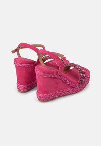 Sandali wedge in suede rosa con dettagli in juta intrecciata, dotati di un accento decorativo di strass e cinturino alla caviglia regolabile.