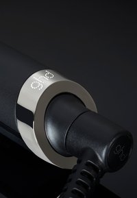 Zwarte stijltang met een metalen zilveren accent en gegraveerd logo. Beschikt over een gladde handgreep en een gestructureerd snoer.