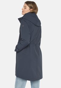 Navyblauer wasserdichter Mantel mit Kapuze, tailliertem Schnitt und seitlichen Taschen. Glatte Textur und elegantes Design, geeignet für verschiedene Wetterbedingungen.