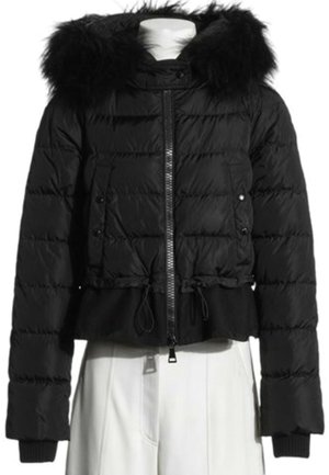 Chaqueta acolchada negra con capucha con borde de piel, cremallera frontal, bolsillos con botones a presión y cordones ajustables en la cintura sobre torso de maniquí blanco.