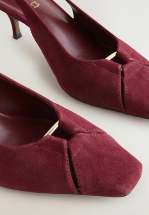 Bordowe zamszowe buty na obcasie typu slingback z kwadratowym noskiem, szczegółem w postaci węzła z przodu oraz małym czarnym obcasem. Gładka tekstura z minimalną ilością przeszyć.