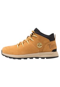 Botă de drumeție din suede maro, cu guler negru, șireturi aurii și talpă din cauciuc. Prezintă un logo embosat și o etichetă cu logo pe lateral.