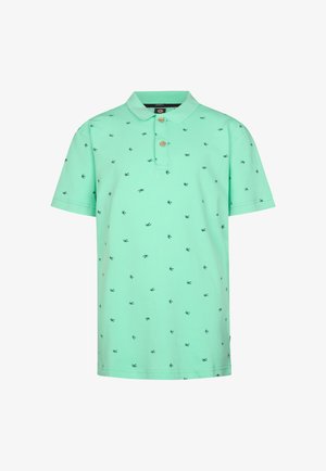 Tricou polo verde mentă cu mâneci scurte, guler și modele mici; asortat cu blugi gri deschis și adidași albi.