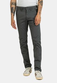 Graue Slim-Fit-Hosen aus Baumwollstoff mit glatter Textur, ausgestattet mit einem Reißverschluss, Vordertaschen und einem dezenten Logo am Bund.