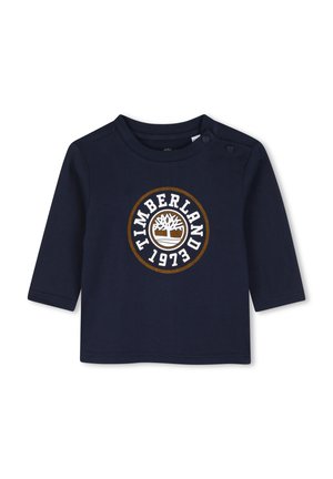 T-shirt bébé à manches longues bleu marine avec logo Timberland et texte 1973 à l'avant, avec deux boutons-pression à l'épaule.