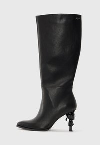 Black knee-high boot made of smooth leather. Features a pointed toe and a distinctive sculptural heel with a decorative accent.