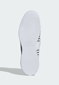 Adidas skosål med en struktureret hvid gummioverflade, der har et udtalt grebmønster og et præget Adidas-logo i midten.