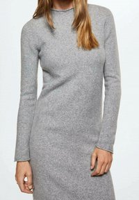 Robe en maille grise à manches longues, col ras du cou et tissu doux et texturé. Silhouette ajustée qui atteint le milieu de la cuisse.