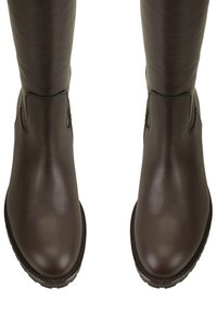 Bottes en cuir marron montantes, avec une texture lisse, un bout rond et des détails cousus le long de la semelle. Design simple sans éléments métalliques.