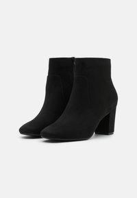 Czarne botki za kostkę wykonane z zamszu, z ostrym noskiem, podwyższonym obcasem i zamkiem błyskawicznym z boku. Gładka faktura i elegancki design.