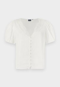 Hvit bluse med puffermer, dyp V-hals og blonder. Har en rad med små knapper foran. Laget av et lett stoff.