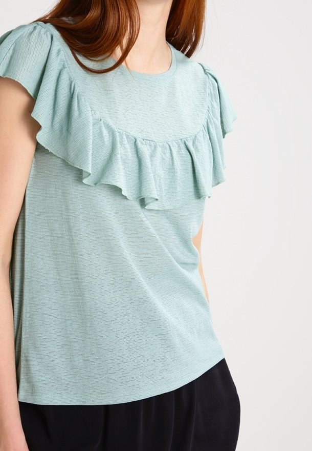Ljusblå kortärmad topp med rynkad halsringning och texturerad tyg. Designad med en avslappnad passform och slät yta.