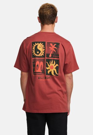 Red cotton t-shirt with a relaxed fit, featuring four bold, graphic prints in black and orange on the back, and "Billabong" text at the bottom.