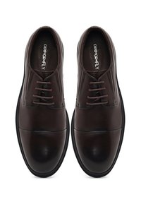 Bruine leren veterschoenen met een gladde afwerking, ronde neus en een lichte glans; zwarte rubberen zool met gestructureerde details langs de rand.