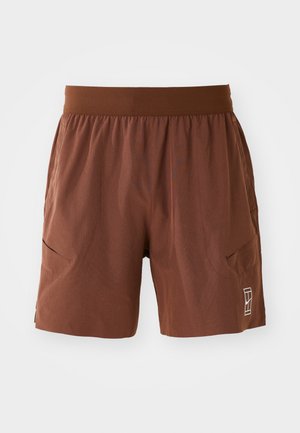 Braune Shorts aus leichtem Material mit elastischem Bund, zwei seitlichen Taschen und einem kleinen Logodetail am rechten Bein.