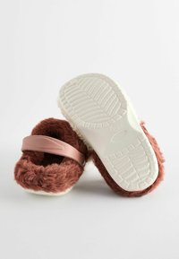 Pantofole marroni morbide con una soffice fodera bianca, dotate di una striscia rosa e una suola in gomma testurizzata per una migliore aderenza.