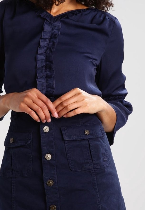 Mörkblå klänning med rynkad front, knäppning fram, och dubbla påsydda fickor, med en avslappnad passform och slät tygkvalitet.