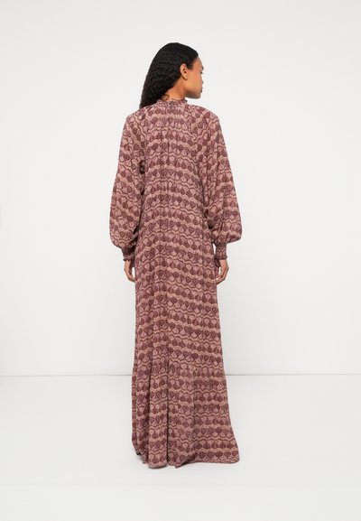 Μάξι φόρεμα σε μοβ λουλουδένιο σχέδιο, με μακριά φουσκωτά μανίκια, ψηλό λαιμό και τιράντες, κατασκευασμένο από ελαφρύ ύφασμα.