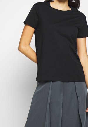 Sort kortærmet bomulds T-shirt med rund hals, glat tekstur og afslappet pasform, der er stylet med en grå plisseret nederdel.