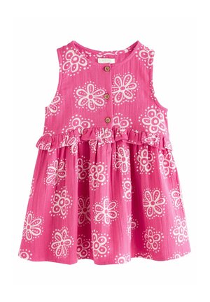 Różowa sukienka na ramiączkach dla malucha, z białym kwiatowym wzorem, drewnianymi guzikami z przodu oraz falbaną w talii.