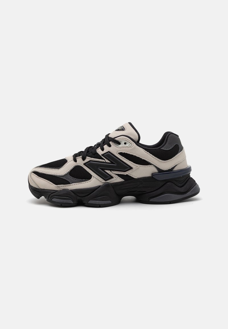 Baskets de sport noires et beiges avec une semelle épaisse, des panneaux en mesh et des lacets noirs, vues du côté extérieur sur un fond clair.