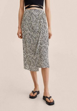 Sort-hvid zebra print midi-nederdel, let stof, omslagsdesign, glat tekstur, kombineret med sorte platformsandaler.