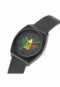 Montre analogique noire avec un cadran carré, dotée d'un cadran noir et d'un logo triangulaire coloré en vert, jaune et rouge. Bracelet en caoutchouc.
