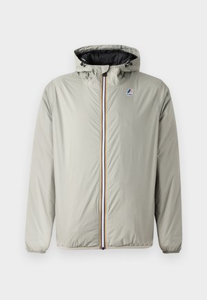 Veste à capuche grise claire en nylon. Dispose d'une fermeture éclair sur le devant avec des rayures colorées et d'un logo brodé sur la poitrine gauche.