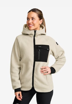Beige fleece jacket with a black zippered chest pocket, high collar, and black accents on the sleeves, featuring a zip closure.