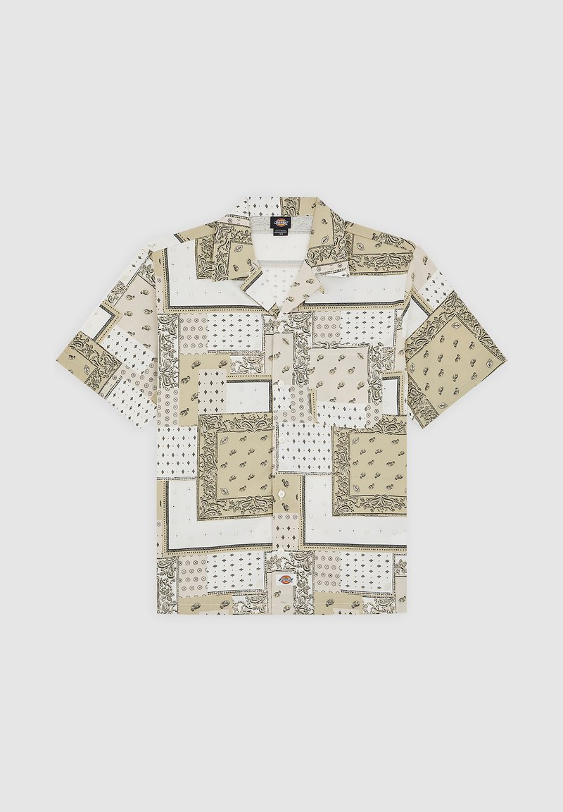 Chemise à manches courtes beige avec divers motifs, notamment floraux et à pois. Présente un devant boutonné et une poche plaquée sur le côté gauche.