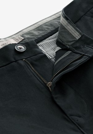 Pantaloni negri cu închidere cu nasture și fermoar, căptușeală interioară cu dungi și textură fină a țesăturii. Cusături și detalii metalice vizibile incluse.