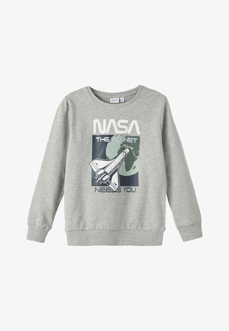 Sweatshirt gris avec un graphique NASA et le texte "LA PLANÈTE A BESOIN DE VOUS" ainsi qu'un design de navette sur le devant. Tissu doux, encolure ronde.