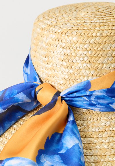 Chapeau de paille à texture tissée serrée, décoré d'un large foulard fleuri bleu et orange noué en nœud autour de la base.